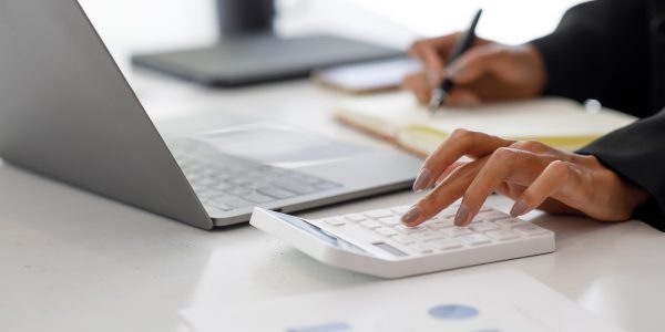 Close up of businesswoman Accounting using calculating income-expenditure and analyzing real estate