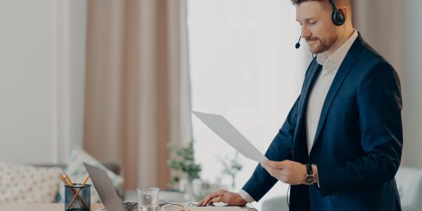 Serious man excutive worker gives presentation of business plan holds paper document