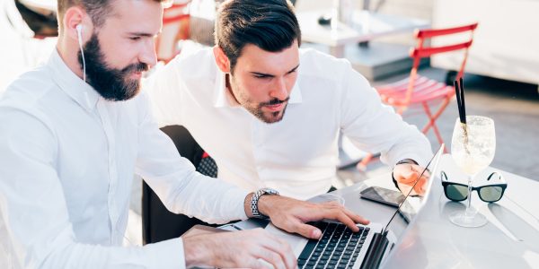 two businessmen outdoor using technology