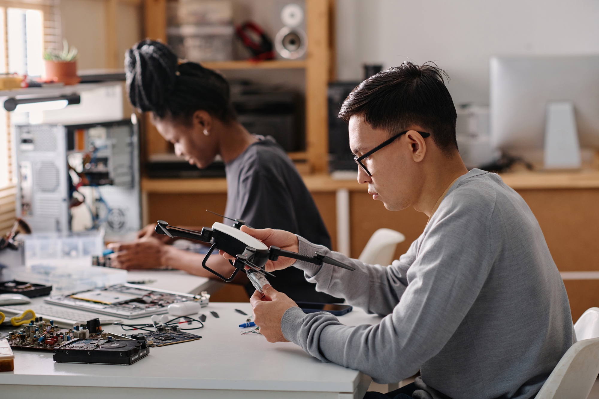 biracial-colleagues-repairing-electronic-devices-in-workshop-1.jpg