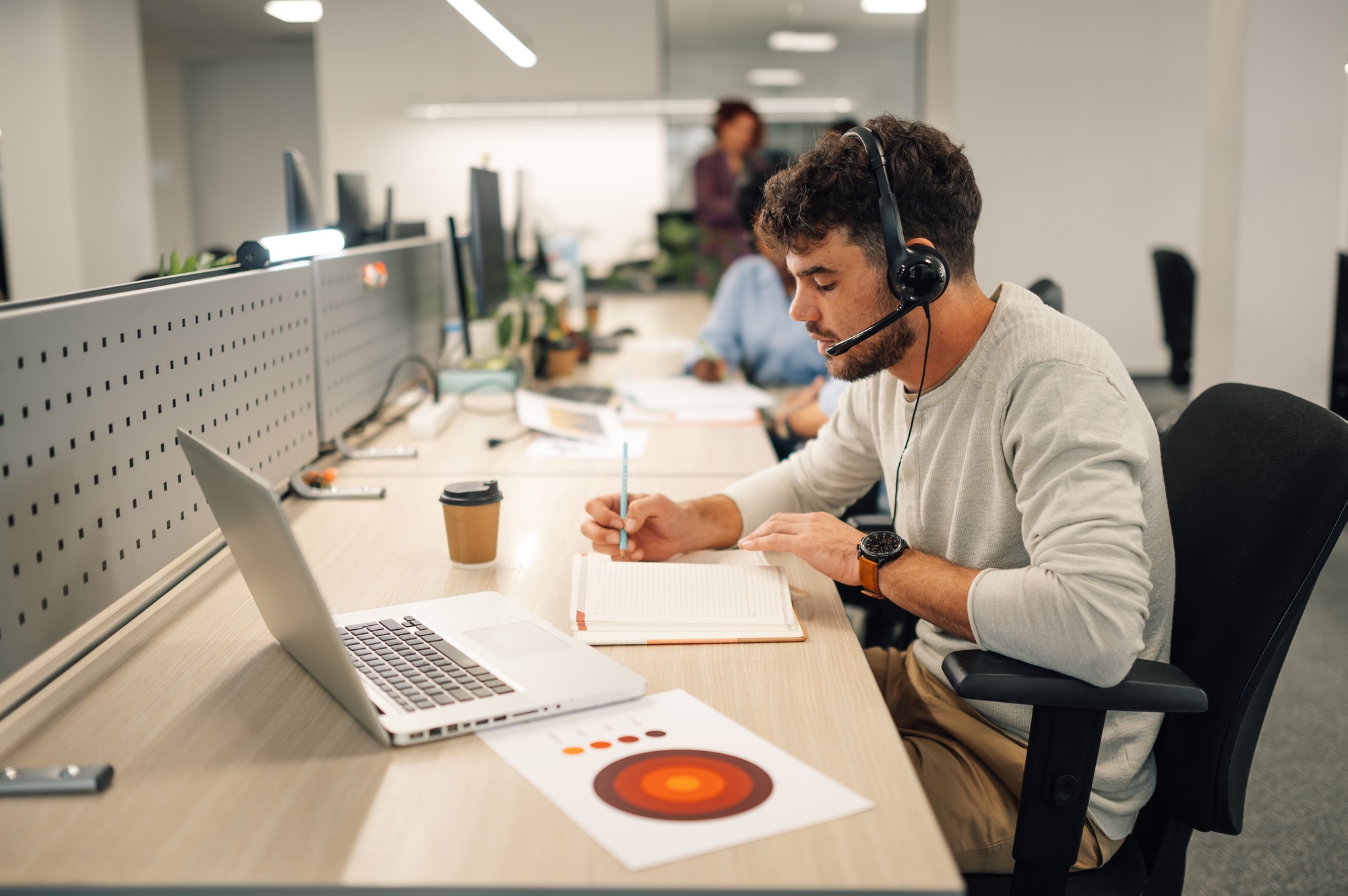 customer-services-agent-with-headset-writing-notes-in-a-call-center-1.jpg