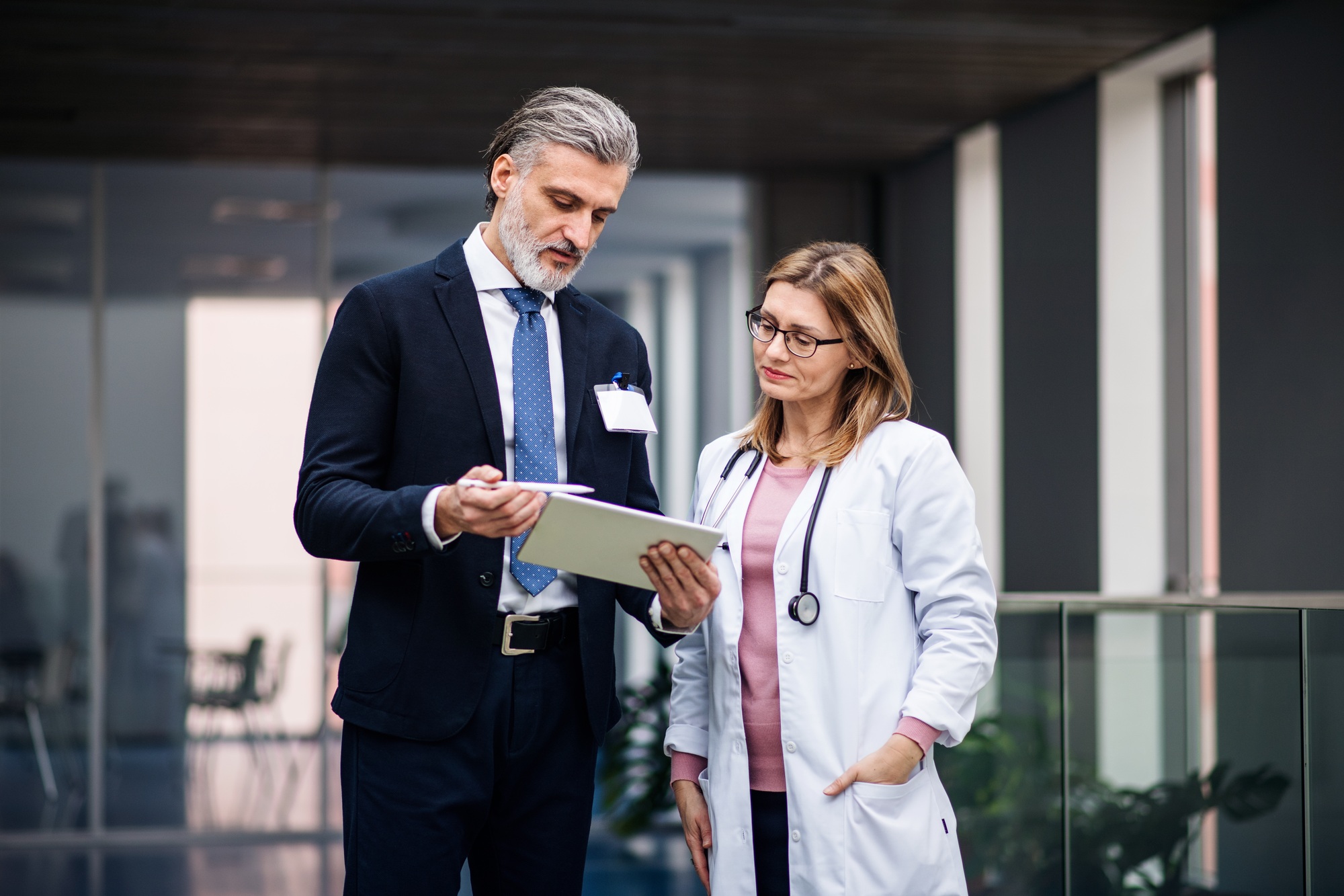 pharmaceutical-sales-representative-with-tablet-talking-to-doctor-1.jpg